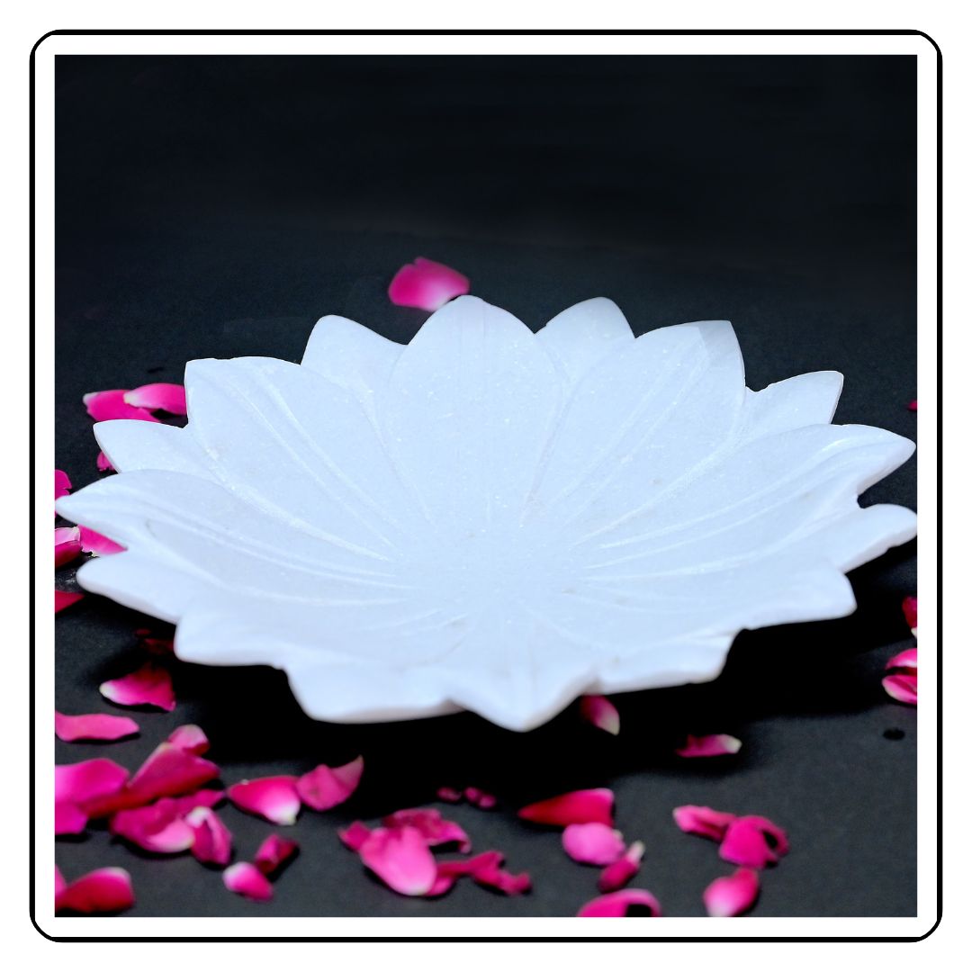 Close-up of a flower-designed marble urli, with a smooth, polished finish and floral detailing."