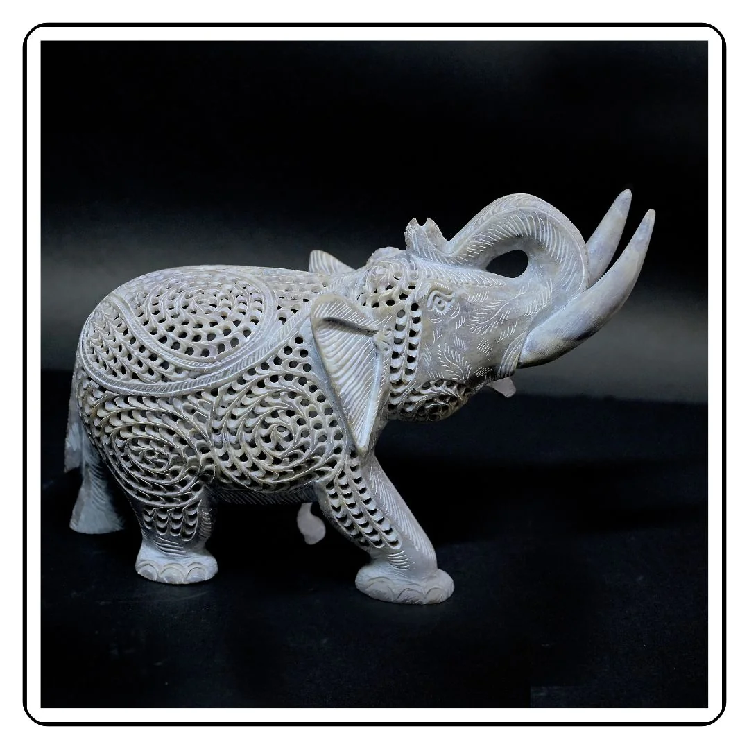 Undercut stone elephant sculpture with miniature elephant carved inside.